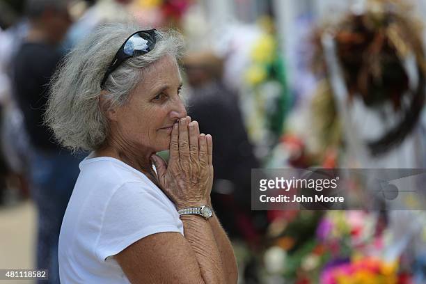 Visiting member of the Order of St. Luke Susan Keefe stands in front of the Emanuel AME Church on the one-month anniversary of the mass shooting on...