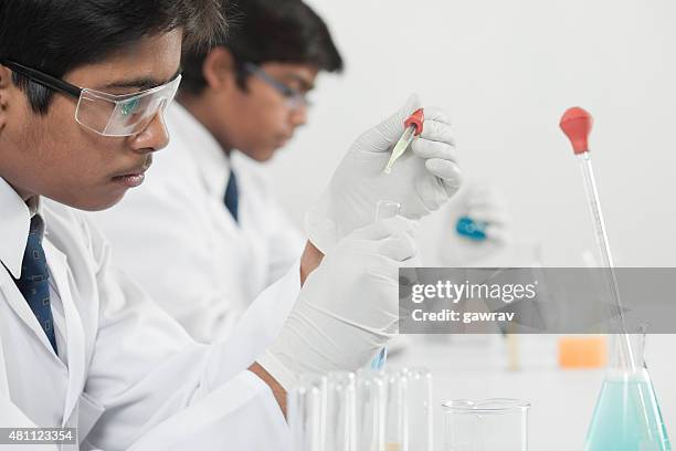 teenage high school science students learning practical chemistry in laboratory. - india lab stockfoto's en -beelden