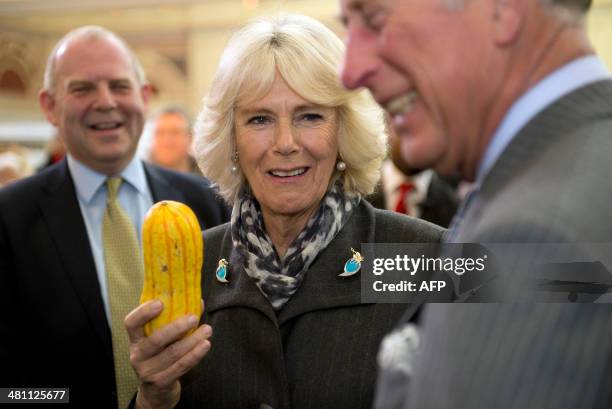 Britain's Camilla, Duchess of Cornwall holds a squash as she shares a joke with Britain's Prince Charles, Prince of Wales and French-born chef...