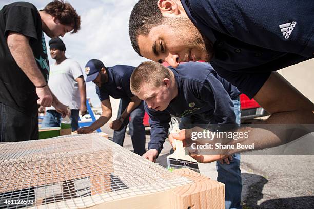 Grant Jerrett of the Tulsa 66ers helps Blake Nay paint a plant stand during the NBA D-League community relations event at A New Leaf, a non-profit...