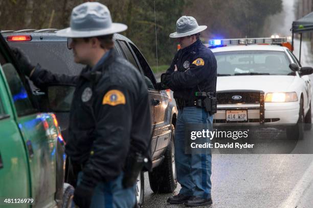 Washington State Patrol troopers stop vehicles at a road block on Washington Highway 530 near a massive mudslide on March 28, 2014 in Darrington,...
