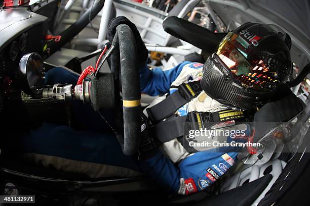 David Gilliland, driver of the Long John Silver's Ford, sits in his car in the garage area during practice for the NASCAR Sprint Cup Series STP 500...