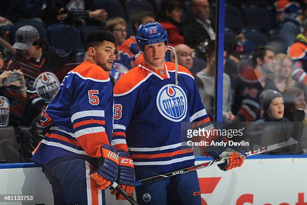 Mark Fraser and Steve MacIntyre of the Edmonton Oilers exchange words prior to a game against the Buffalo Sabres on March 20, 2014 at Rexall Place in...