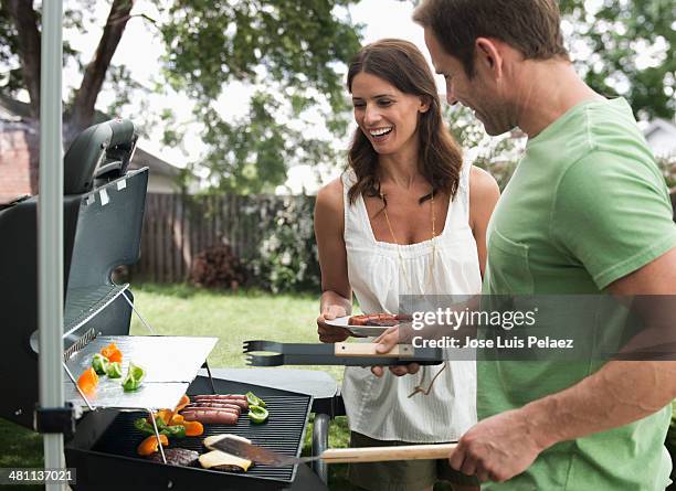 couple at the grill - couple grilling stock pictures, royalty-free photos & images