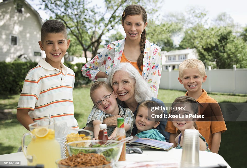 Portrait of grandmother and children in backyard