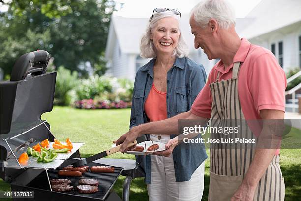 elderly couple at the grill - couple grilling stock pictures, royalty-free photos & images