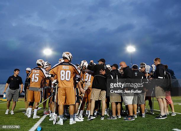 Donny Moss, John Ranagan and Randy Staats of the Rochester Rattlers talk with teammates and coaches on the sidelines during a break in play against...
