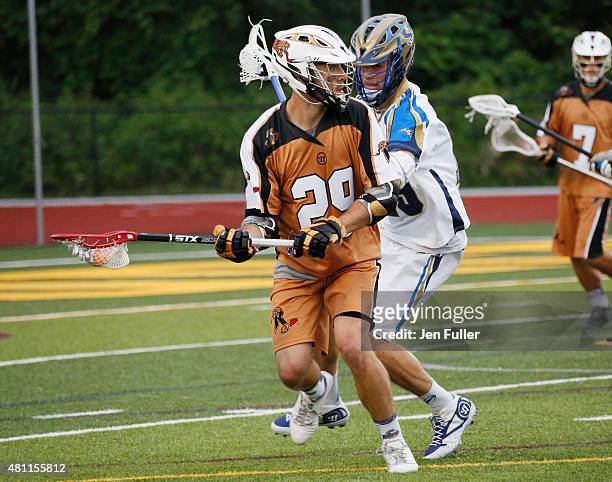 Jordan MacIntosh of the Rochester Rattlers carries the ball against Kevin Drew of the Charlotte Hounds at Eunice Kennedy Shriver Stadium on July 17,...