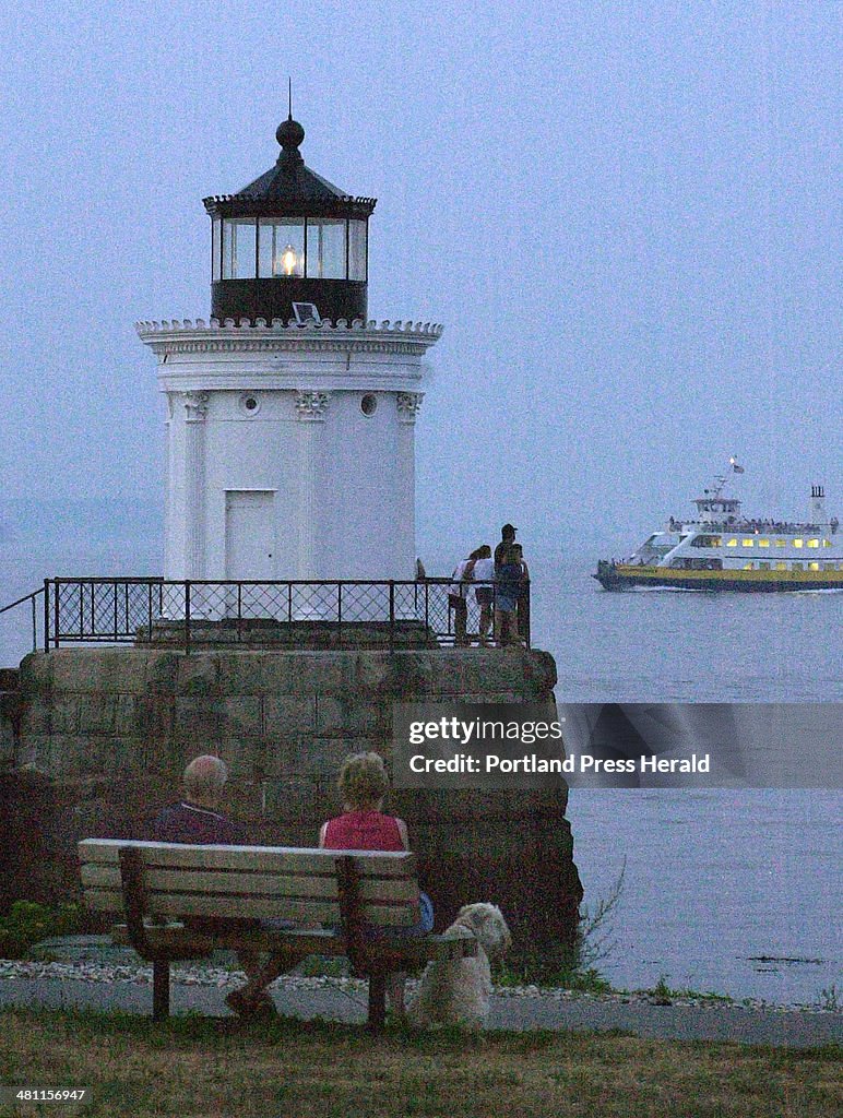The Bug Light is lit off the South Portland waterfront as a Casco Bay lines ferry motors by and Rola...
