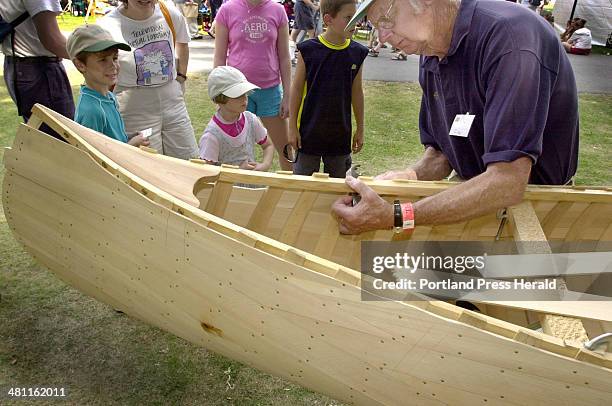 Staff Photo by Jill Brady, Sun, Aug 04, 2002: Burt Libby of Litchfield planks a section of his traditional cedar canvas canoe at the 26th annual...