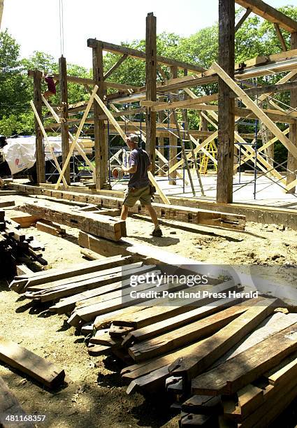 Staff Photo by Doug Jones, Fri, Jul 20, 2001:John Courtney at the post and beam barn construction site with support braces salvaged from another barn...
