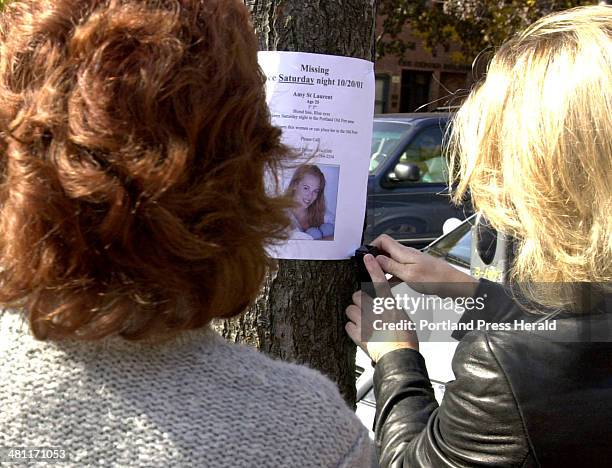 Staff Photo by Doug Jones, Tue, Oct 23, 2001:Patty Morris and Gail Landry, right, post notices of their coworker Amy St. Laurent, around Portland's...