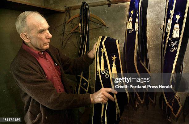 Staff Photo by Doug Jones, Thu, May 08, 2003: Donald Adams, Master of Sagadahoc Grange in Bowdoin center, collects the sashes of the 15 officers of...