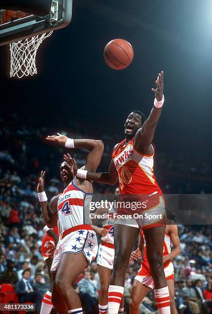 Wayne Rollins of the Atlanta Hawks fights for a rebound with Rick Mahorn of the Washington Bullets during an NBA basketball game circa 1984 at the...