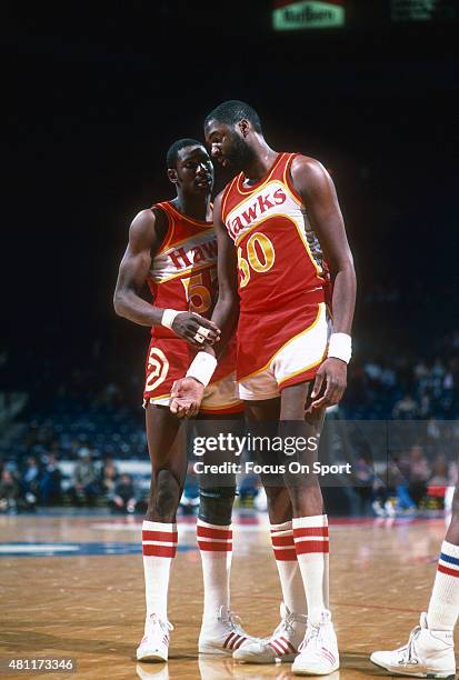 Wayne Rollins of the Atlanta Hawks talks with teammate Cliff Livingston while there is a break in the action against the Washington Bullets during an...