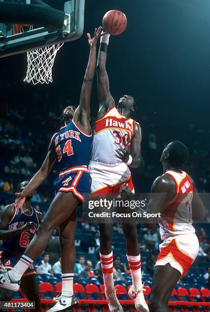 Wayne Rollins of the Atlanta Hawks battles for rebound with Charles Oakley of the New York Knicks during an NBA basketball game circa 1984 at the...