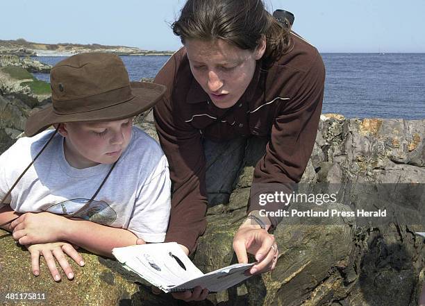 Staff photo by Gregory Rec -- Tuesday, May 1, 2001 -- Anastasia Grechen, a naturalist with the Ferry Beach Ecology School, looks over a field guide...