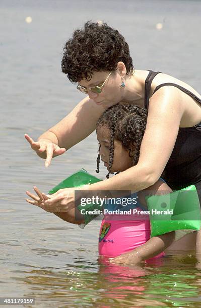 Staff Photo by Jill Brady, Thursday, July 5, 2001: Lori Rosenbauer teaches her daughter, Eliana the importance of putting your fingers together when...