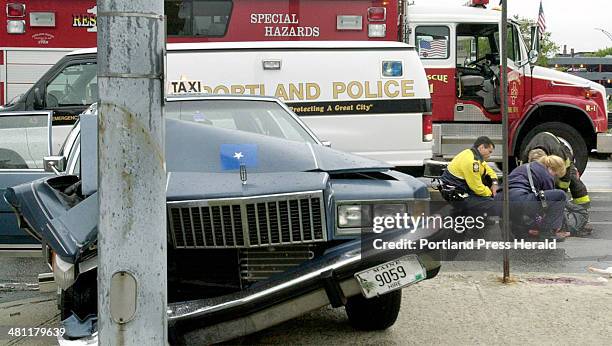 Staff Photo by John Ewing, Friday, September 28, 2001: Portland rescue personnel tend to Ahmed A. Hassan, the driver of a Kismayo Taxi cab that...