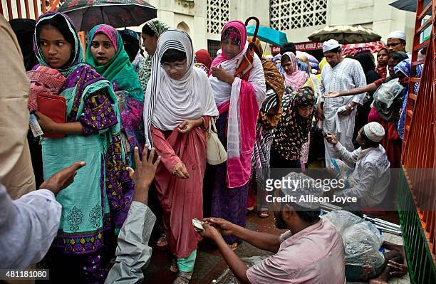 Bangladeshi Muslims give alms to beggars after prayers at Baitul Mukarram, the National Mosque, on Eid Al-Fitr July 18, 2015 in Dhaka, Bangladesh....