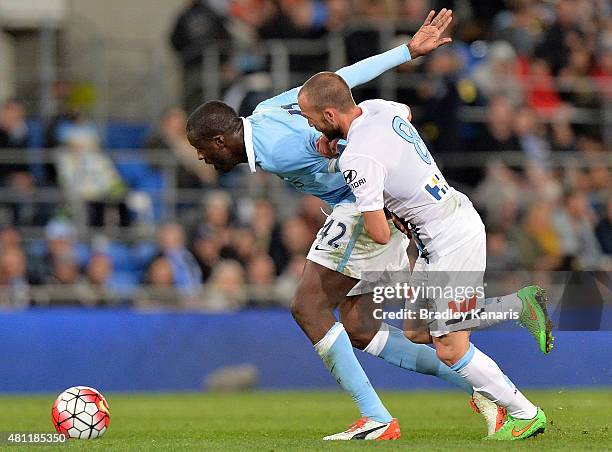 Yaya Toure of Manchester City and Jason Trifiro of Melbourne compete for the ball during the international friendly match between Melbourne City and...