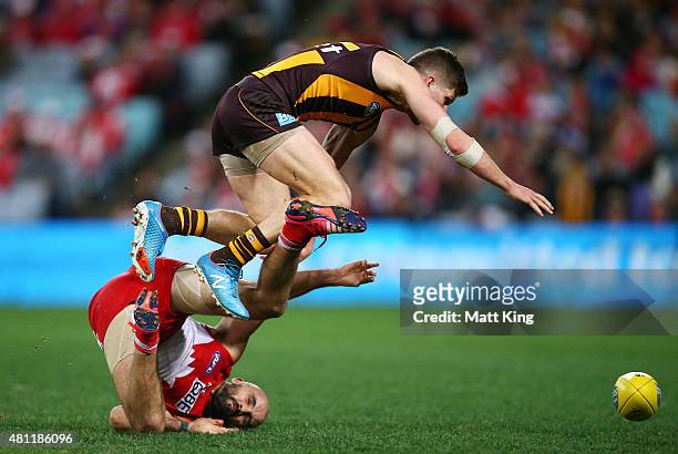 Luke Breust of the Hawks trips over Rhyce Shaw of the Swans during the round 16 AFL match between the Sydney Swans and the Hawthorn Hawks at ANZ...