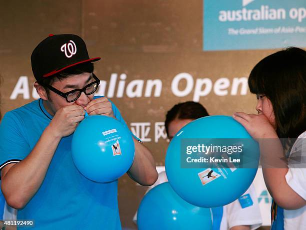 Chinese pop senstion Wang Zhengliang competes with children in a balloon blowing competition at an Australian Open 2016 event on July 19, 2015 in...