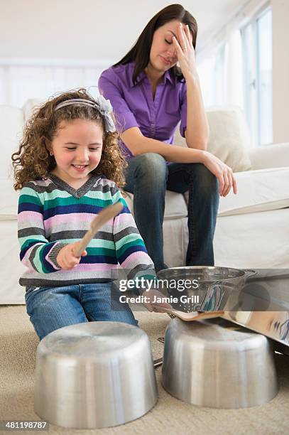 daughter banging on pots, mother with headache - mom head in hands stock pictures, royalty-free photos & images