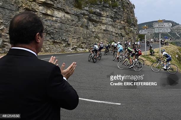 French President Francois Hollande applauds as he looks at cyclists riding during the 178,5 km fourteenth stage of the 102nd edition of the Tour de...