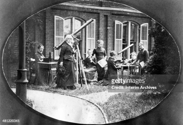 Astronomer Maria Mitchell , standing second from left, next to a telescope, is shown with her astronomy class outside the observatory, at Vassar...