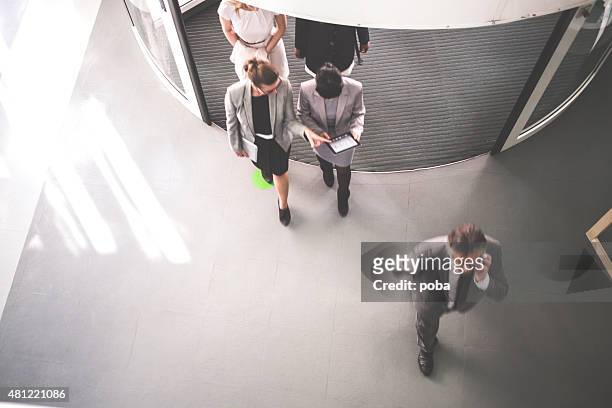 group of successful businesspeople walking - walking into door stock pictures, royalty-free photos & images