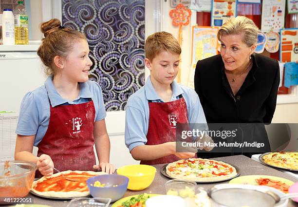 Sophie, Countess of Wessex talks with students making pizza as she sits in on cookery lesson during a visit to the Queensgate Foundation Primary...