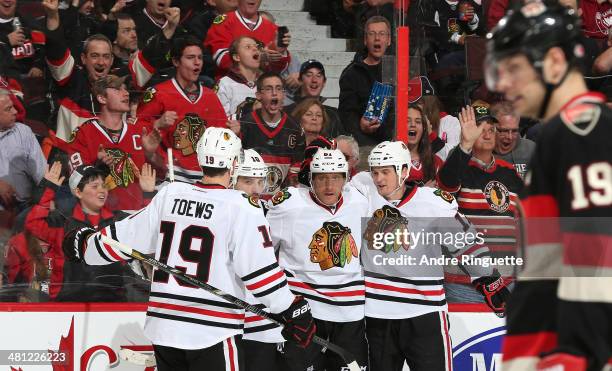 Marian Hossa of the Chicago Blackhawks celebrates his second period goal against the Ottawa Senators with teammates Jonathan Toews, Patrick Sharp and...