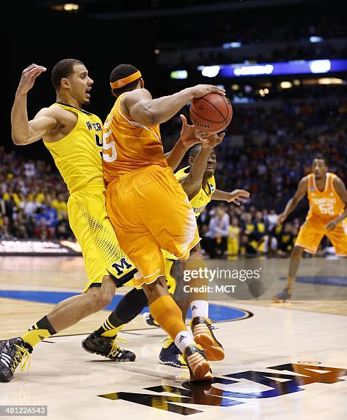 Michigan Wolverines forward Jordan Morgan takes a charge with less than 10 seconds left against Tennessee Volunteers forward Jarnell Stokes ....