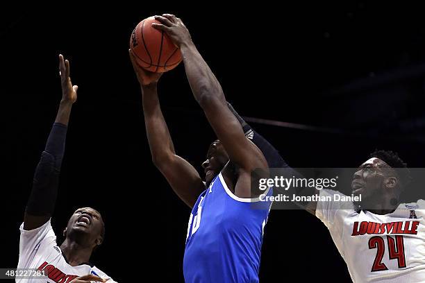 Julius Randle of the Kentucky Wildcats shoots the ball against Mangok Mathiang and Montrezl Harrell of the Louisville Cardinals in the first half...