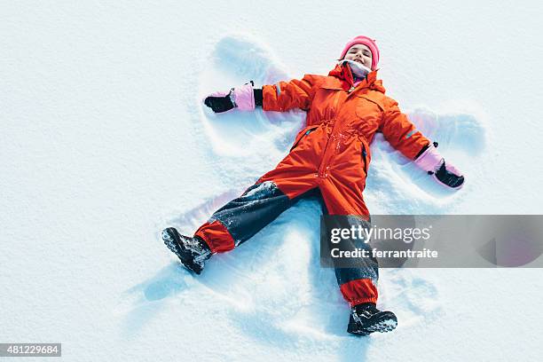 little girl making a snow angel - snow angel 個照片及圖片檔