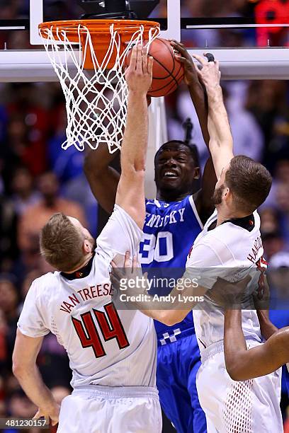 Stephan Van Treese and Luke Hancock of the Louisville Cardinals defend Julius Randle of the Kentucky Wildcats during the regional semifinal of the...