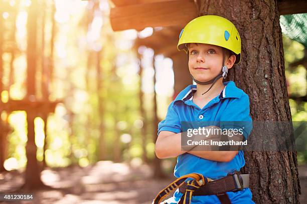 glücklich kleiner junge in einem zip line adventure park - hochseilgarten stock-fotos und bilder