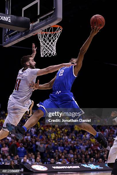 Aaron Harrison of the Kentucky Wildcats shoots the ball over Luke Hancock of the Louisville Cardinals during the regional semifinal of the 2014 NCAA...