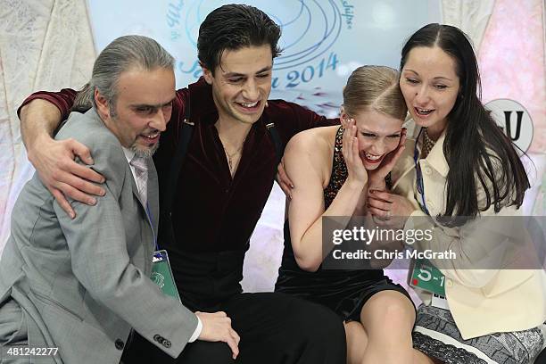 Coach Pasquale Camerlengo, skaters Andrew Poje and Kaitlyn Weaver of Canada and coach Anjelika Krylova react after seeing their score in the Ice...