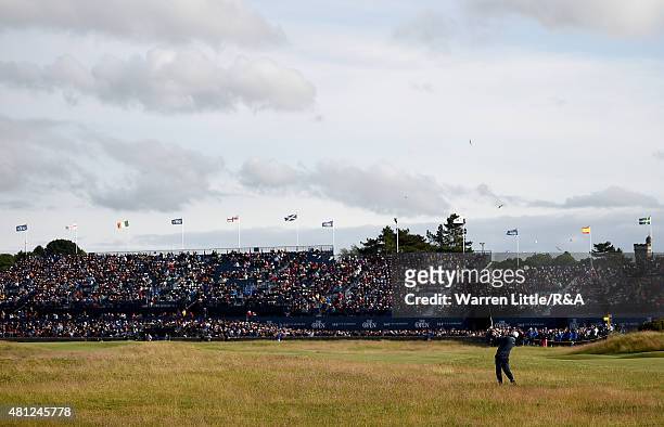 Kevin Kisner of the United States hits an approach on the 17th hole a grandstand of fans look on during the second round of the 144th Open...