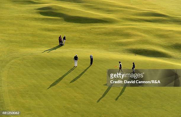 Eddie Pepperell of England, Raphael Jacquelin of France and David Hearn of Canada play the 18th green during the second round of the 144th Open...