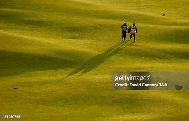 Adam Bland of Australia and his caddie Matthew Butlar walk up the 18th hole during the second round of the 144th Open Championship at The Old Course...