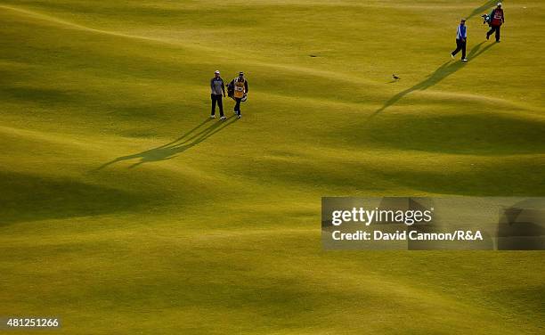 Adam Bland of Australia and his caddie Matthew Butlar along with Daniel Brooks of England and his caddie walk up the 18th hole during the second...