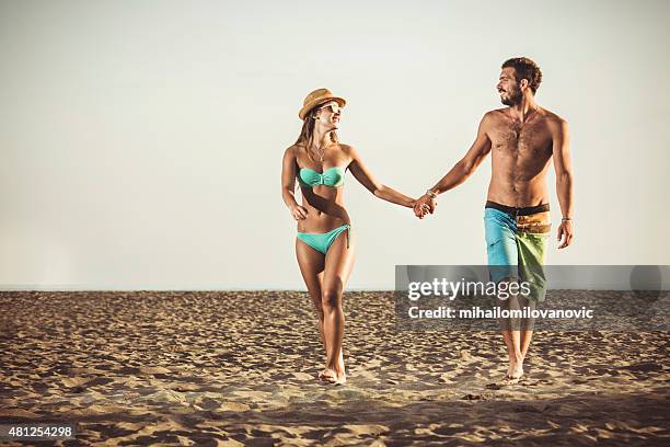 happy couple walking at the beach - swimsuit girlfriend stock pictures, royalty-free photos & images