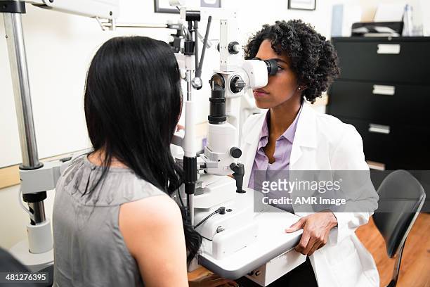 annual eye exam by optometrist - eye test equipment stock pictures, royalty-free photos & images