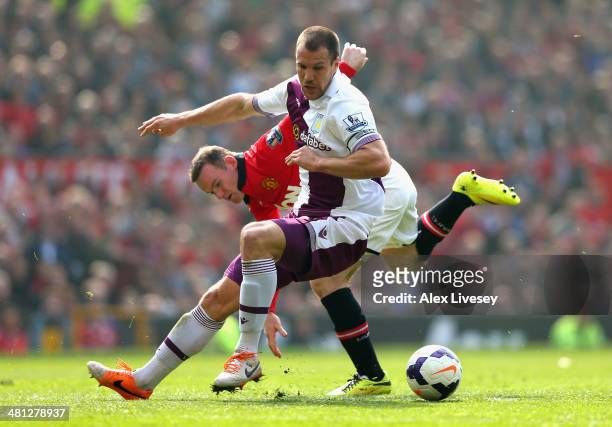Wayne Rooney of Manchester United tangles with Ron Vlaar of Aston Villa during the Barclays Premier League match between Manchester United and Aston...