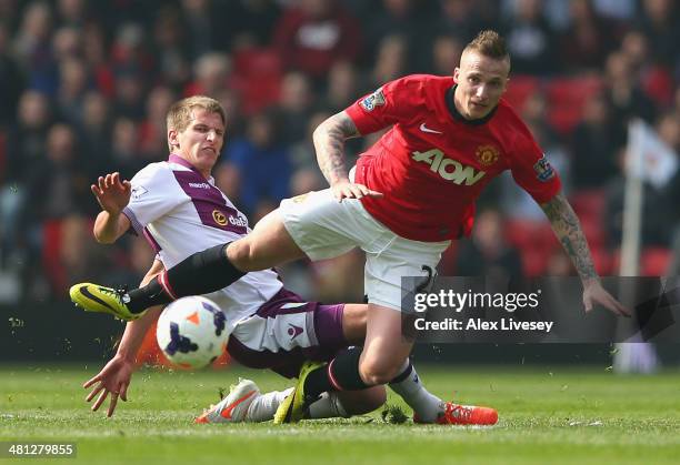 Marc Albrighton of Aston Villa challenges Alexander Buttner of Manchester United during the Barclays Premier League match between Manchester United...