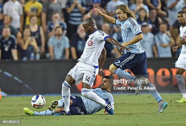 Mid-fielder Paulo Nagamura of Sporting Kansas City kicks the ball away from forward Nigel Reo-Coker of the Montreal Impact during the second half on...