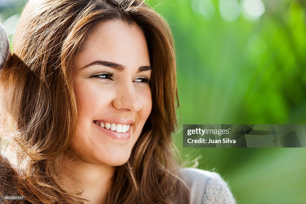 Young woman outdoors looking away smiling